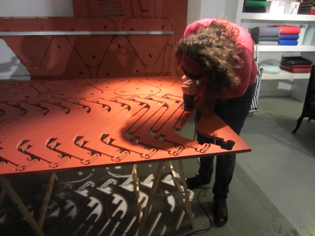 Mariana cutting a Cut Furniture stool